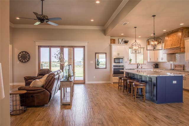 kitchen featuring appliances with stainless steel finishes, baseboards, light wood-style flooring, and open floor plan