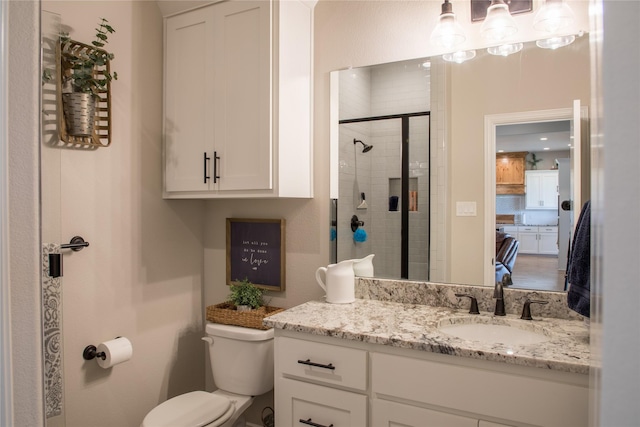 bathroom featuring vanity, a tile shower, and toilet