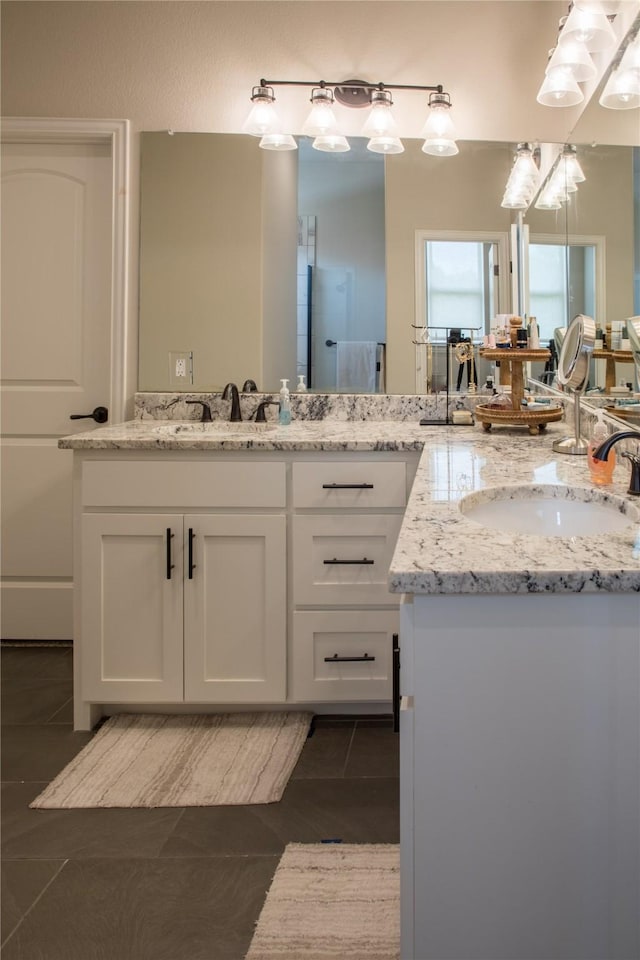 bathroom with tile patterned floors, two vanities, and a sink