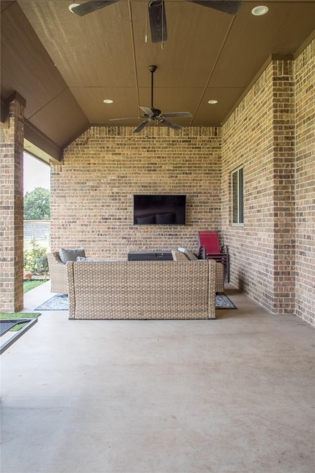 view of patio featuring ceiling fan and an outdoor living space with a fireplace