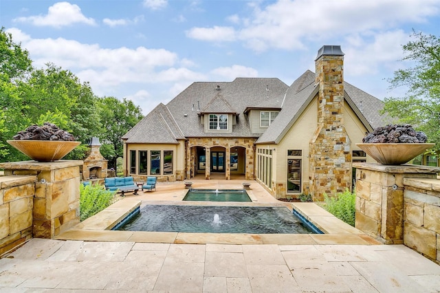 1342 Steeple Chase Ln, Aledo, TX 76008 - back of property with stone siding, a patio, a chimney, an outdoor living space with a fireplace, and an in ground hot tub