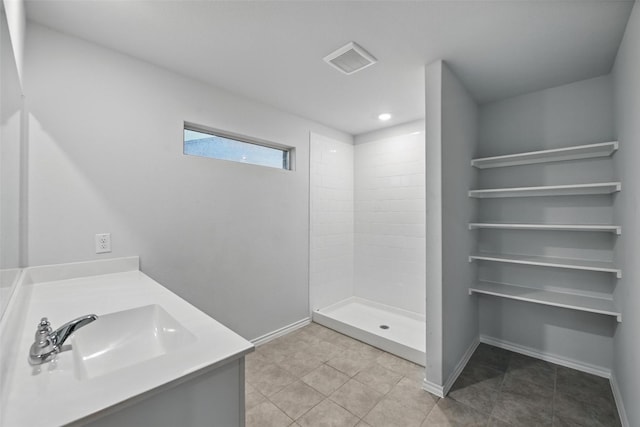 624 Whitecomb Ln, Justin, TX 76247 - bathroom with visible vents, a sink, baseboards, tile patterned floors, and tiled shower
