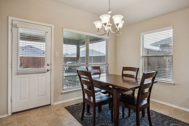 dining area with baseboards, a notable chandelier, and a healthy amount of sunlight