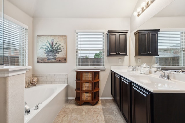 bathroom with baseboards, a sink, a bath, and double vanity