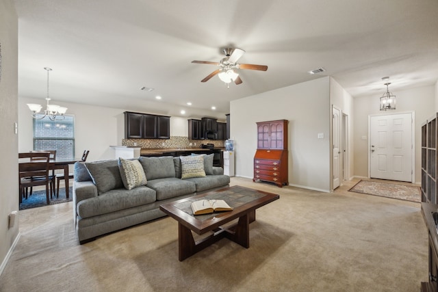 living area featuring visible vents, baseboards, ceiling fan with notable chandelier, and light carpet
