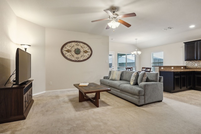 living room with visible vents, baseboards, light colored carpet, and ceiling fan with notable chandelier