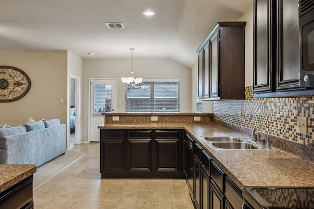 kitchen with visible vents, a sink, a peninsula, lofted ceiling, and an inviting chandelier