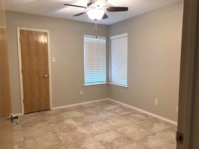empty room featuring baseboards and a ceiling fan
