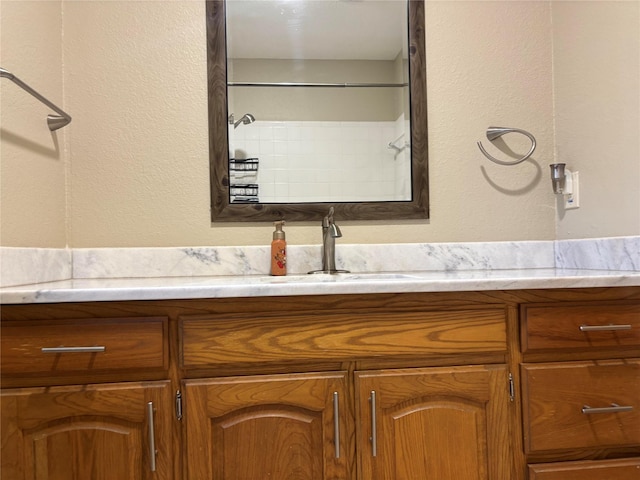 bathroom with vanity and a textured wall