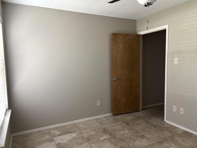 empty room featuring baseboards and ceiling fan