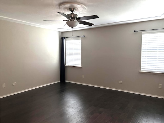 spare room featuring dark wood-type flooring, baseboards, and ceiling fan