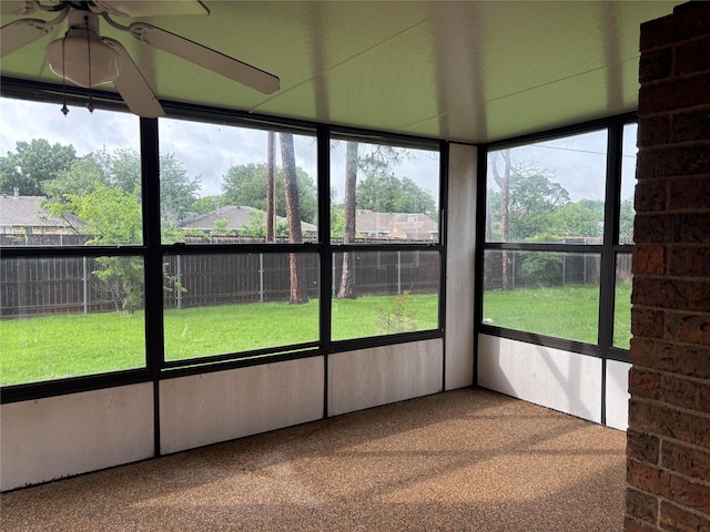 unfurnished sunroom with a ceiling fan