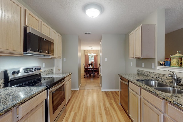 3073 Dusty Ridge Dr, Rockwall, TX 75032 - kitchen with stainless steel appliances, visible vents, a sink, and light brown cabinets