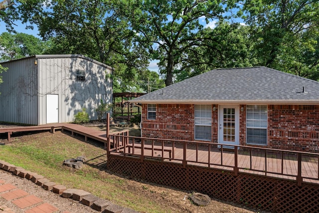 200 Bushwhacker Dr, Mabank, TX 75156 - rear view of property featuring a wooden deck, a shingled roof, an outdoor structure, and brick siding