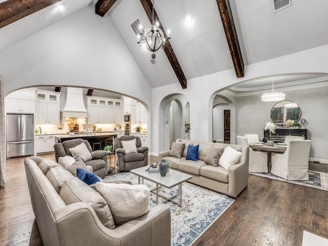3515 Terrace Way, Celina, TX 75009 - living area with arched walkways, high vaulted ceiling, beamed ceiling, a chandelier, and wood finished floors