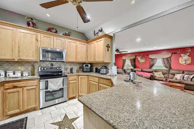 kitchen featuring ceiling fan, a peninsula, open floor plan, light brown cabinets, and stainless steel appliances