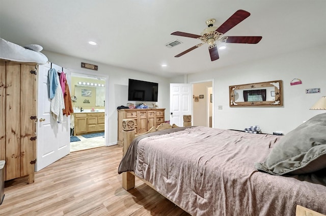 bedroom featuring ensuite bath, recessed lighting, visible vents, and light wood-style floors