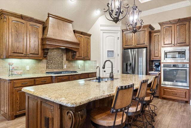 1408 Joshua Way, Granbury, TX 76048 - kitchen with appliances with stainless steel finishes, a sink, light wood-style floors, a chandelier, and custom range hood