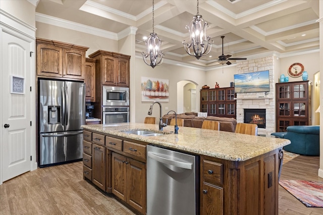 1408 Joshua Way, Granbury, TX 76048 - kitchen featuring a sink, a fireplace, arched walkways, ceiling fan with notable chandelier, and stainless steel appliances