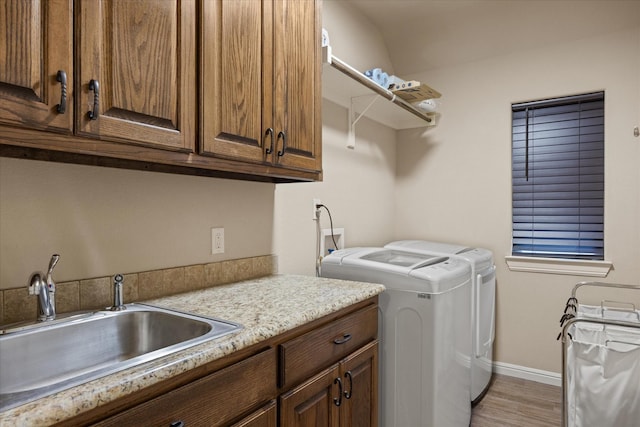 1408 Joshua Way, Granbury, TX 76048 - laundry area featuring independent washer and dryer, cabinet space, a sink, baseboards, and light wood finished floors