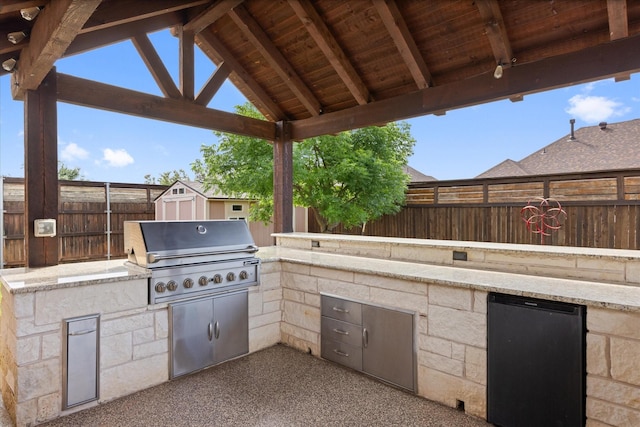 1408 Joshua Way, Granbury, TX 76048 - view of patio featuring an outdoor structure, a grill, a fenced backyard, exterior kitchen, and a storage shed