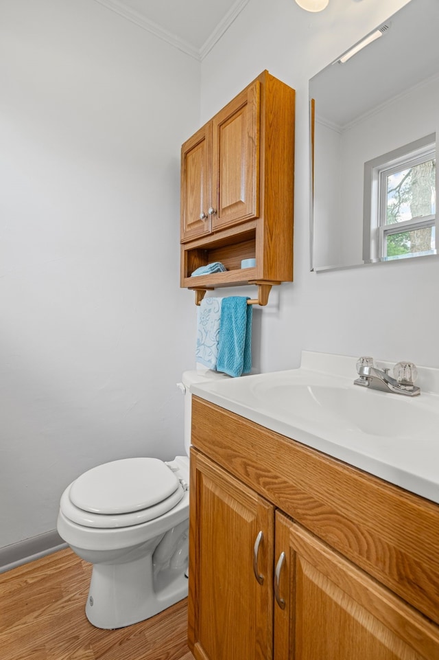 356 Bedford Ct E, Bedford, TX 76022 - half bathroom featuring vanity, ornamental molding, wood finished floors, toilet, and baseboards