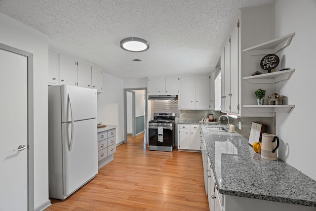 356 Bedford Ct E, Bedford, TX 76022 - kitchen with stainless steel gas range, open shelves, a sink, freestanding refrigerator, and under cabinet range hood