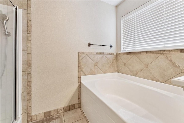 bathroom with tile patterned floors, a shower stall, and a bath