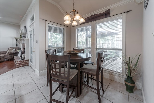dining room with an inviting chandelier, ornamental molding, baseboards, and light tile patterned flooring
