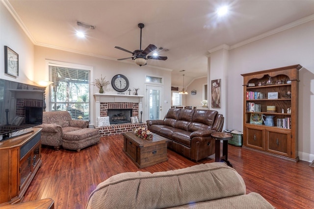 living area featuring ornamental molding, a fireplace, ceiling fan with notable chandelier, and visible vents