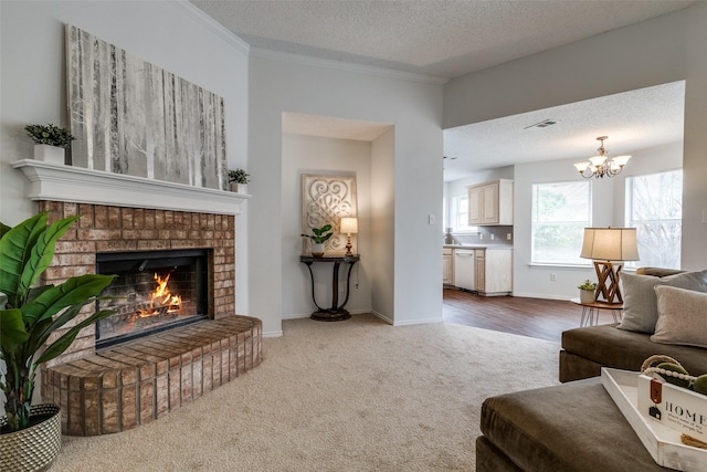 3804 Periwinkle Dr, Fort Worth, TX 76137 - carpeted living room with a brick fireplace, a notable chandelier, a textured ceiling, baseboards, and ornamental molding