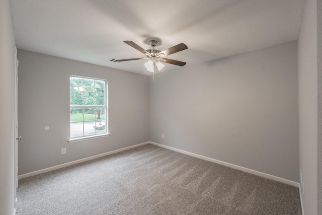spare room featuring carpet floors, a ceiling fan, and baseboards