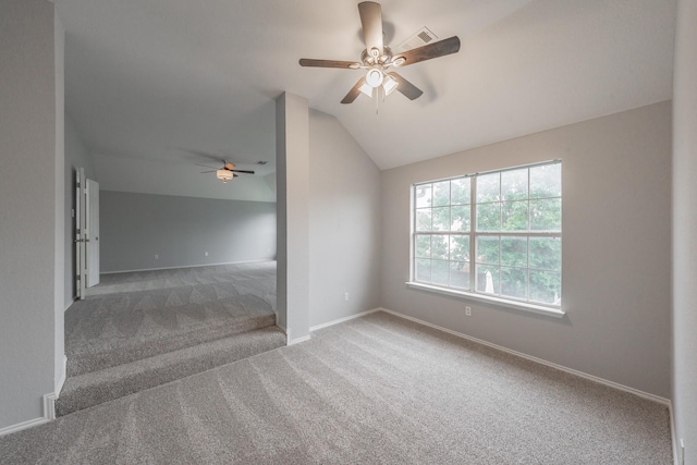 carpeted empty room with visible vents, a ceiling fan, baseboards, and vaulted ceiling