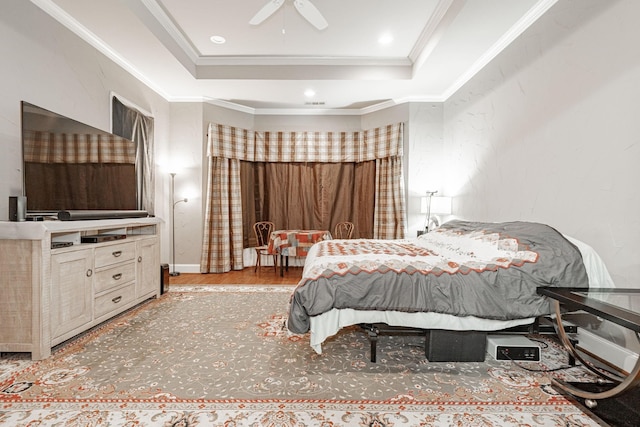 bedroom featuring crown molding, visible vents, wood finished floors, ceiling fan, and a raised ceiling