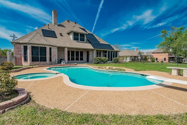 view of pool featuring fence, a diving board, a pool with connected hot tub, a patio area, and a yard