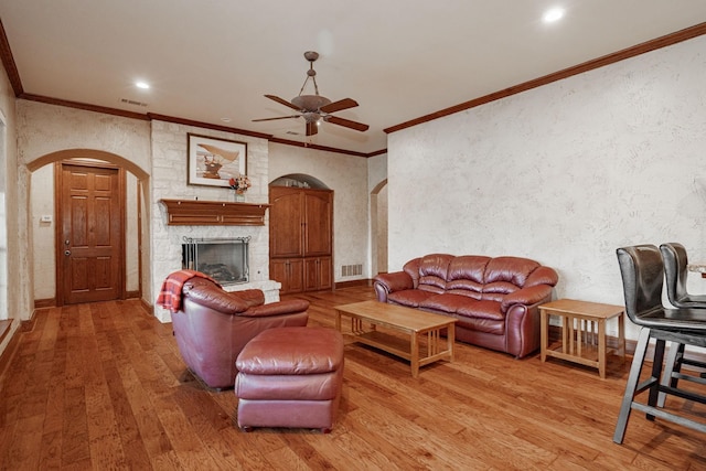 living room featuring arched walkways, ceiling fan, visible vents, and hardwood / wood-style flooring