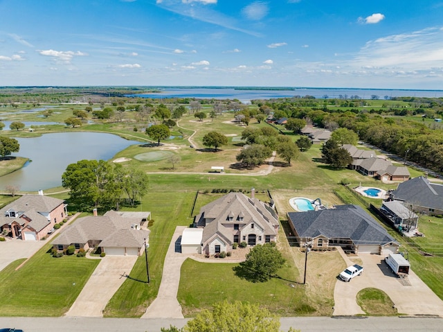 drone / aerial view featuring a water view, view of golf course, and a residential view