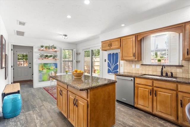 kitchen with a sink, dark wood finished floors, a center island, decorative backsplash, and stainless steel dishwasher