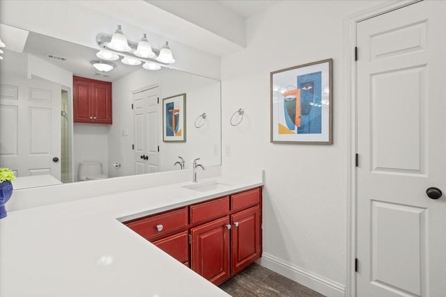 full bath with vanity, toilet, baseboards, wood finished floors, and visible vents