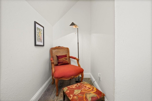 sitting room featuring baseboards, lofted ceiling, and wood finished floors