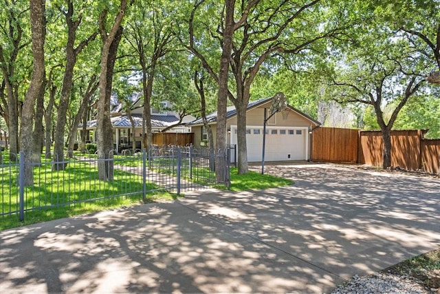ranch-style home with a garage, fence, driveway, and a gate