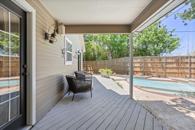 wooden terrace with a fenced in pool and a fenced backyard