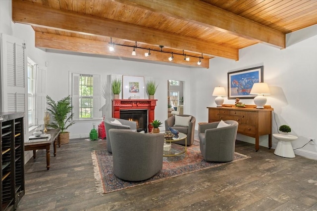 sitting room with wood ceiling, a lit fireplace, rail lighting, baseboards, and hardwood / wood-style floors