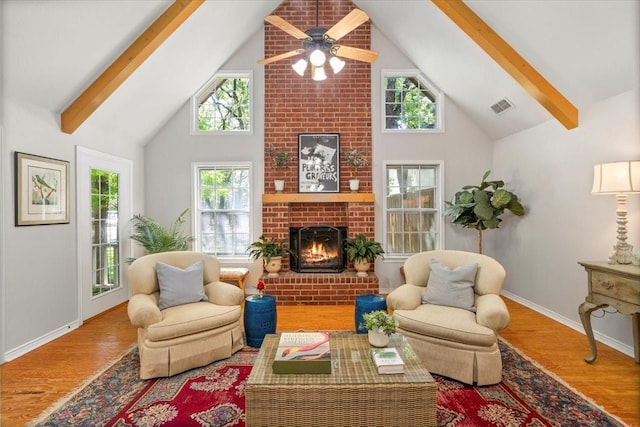 living area featuring high vaulted ceiling, beamed ceiling, wood finished floors, and visible vents