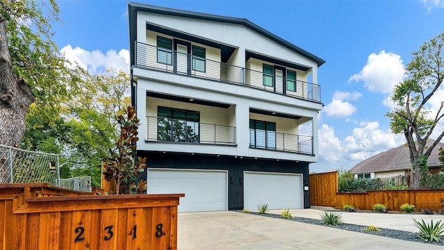 2316 Arroyo Ave, Dallas, TX 75219 - modern home featuring a balcony, stucco siding, fence, driveway, and a garage