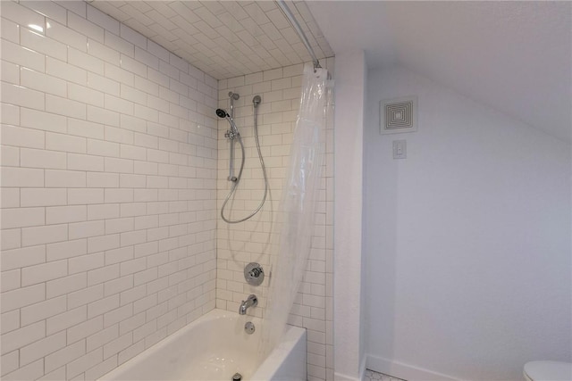 bathroom featuring vaulted ceiling, baseboards, shower / bath combo, and toilet
