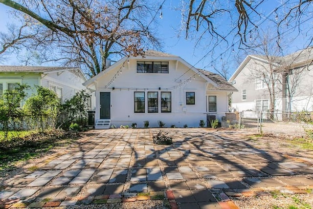 back of house with entry steps, fence, a patio area, and stucco siding