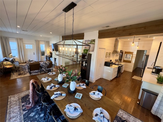 dining space with visible vents, wood walls, dark wood-style floors, a chandelier, and recessed lighting