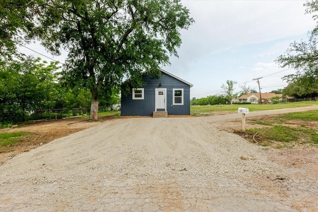 view of outdoor structure featuring fence and driveway