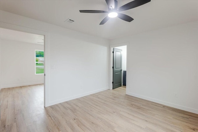 spare room with a ceiling fan, baseboards, visible vents, and light wood-style flooring